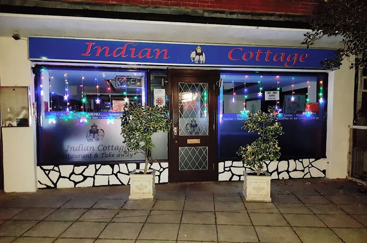Indian Cottage restaurant shopfront on Havant Road, Horndean, lit up at night